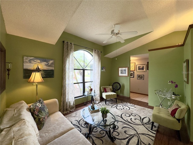 living room featuring ceiling fan, a textured ceiling, light hardwood / wood-style flooring, and lofted ceiling