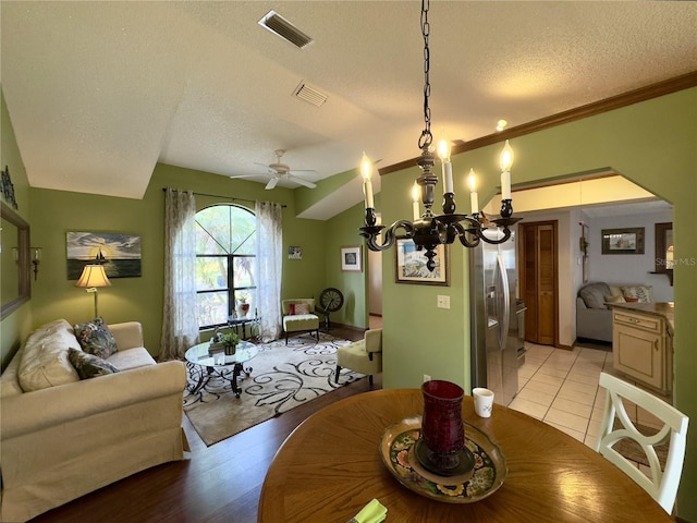 dining space featuring ceiling fan, light wood-type flooring, crown molding, and a textured ceiling