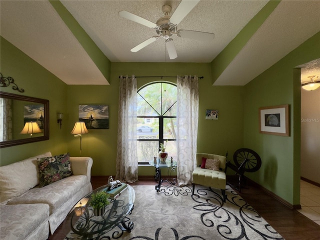 living room with a textured ceiling, ceiling fan, vaulted ceiling, and hardwood / wood-style floors