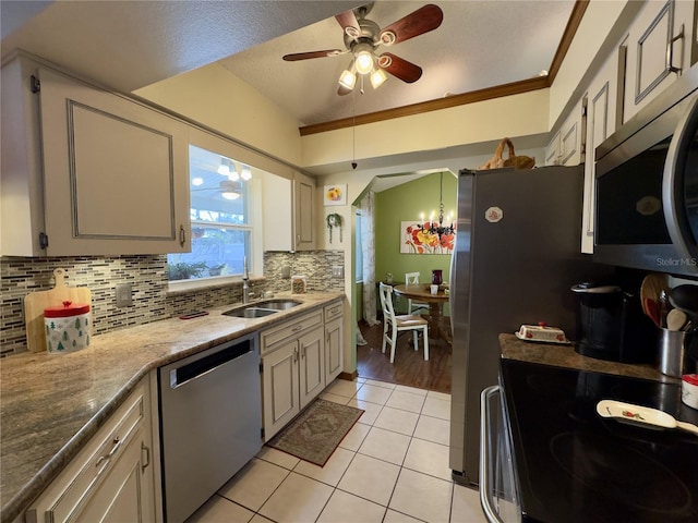 kitchen featuring tasteful backsplash, sink, stainless steel appliances, ornamental molding, and light tile patterned floors