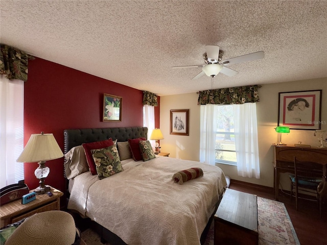 bedroom with ceiling fan, a textured ceiling, and dark hardwood / wood-style floors