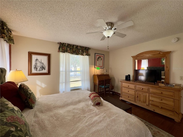 bedroom with ceiling fan, dark wood-type flooring, and a textured ceiling