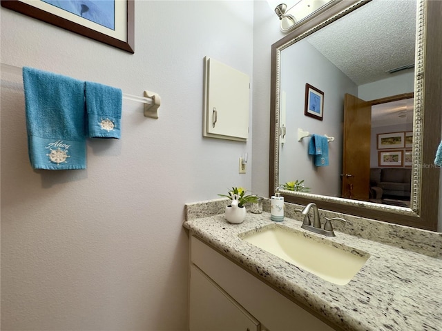 bathroom featuring a textured ceiling and vanity