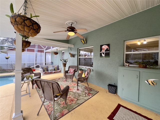 view of patio / terrace featuring ceiling fan and glass enclosure