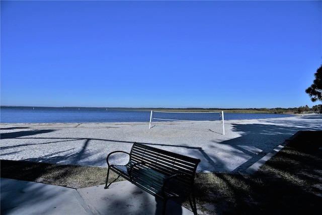 exterior space with volleyball court and a water view