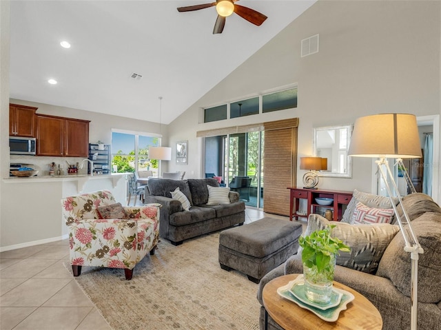 tiled living room with ceiling fan, sink, and high vaulted ceiling