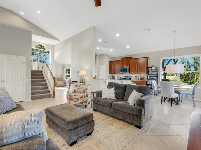 living room featuring high vaulted ceiling and light tile patterned floors