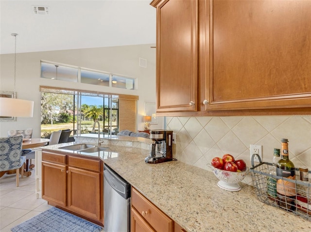 kitchen featuring sink, light stone counters, vaulted ceiling, light tile patterned floors, and stainless steel dishwasher