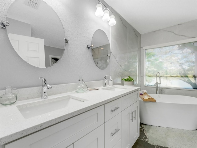 bathroom with a bathing tub, tile patterned floors, and vanity