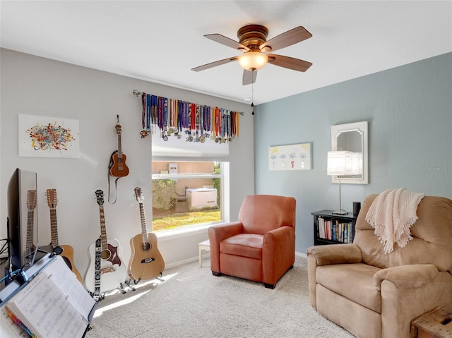 living area featuring light colored carpet and ceiling fan