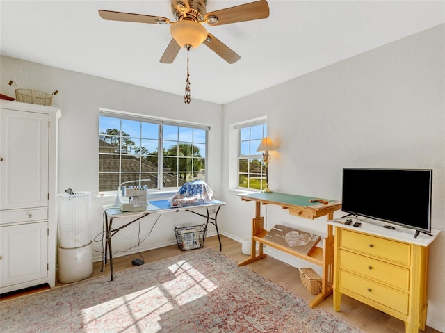 home office with ceiling fan and light hardwood / wood-style floors