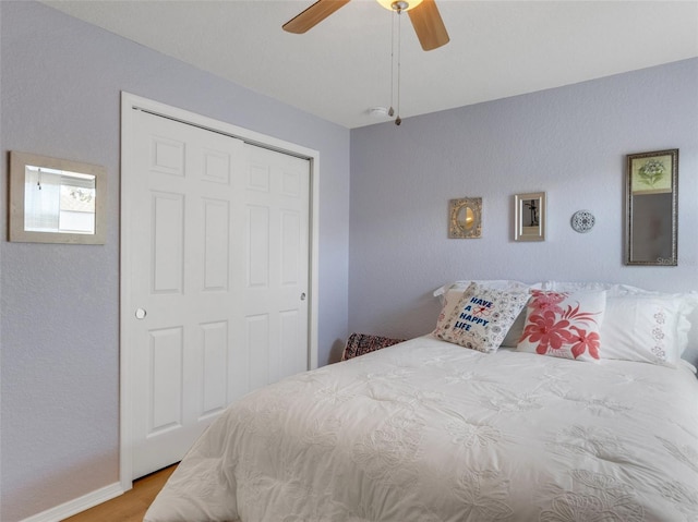 bedroom with a closet, ceiling fan, and light wood-type flooring