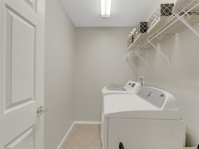 clothes washing area with separate washer and dryer and light tile patterned floors