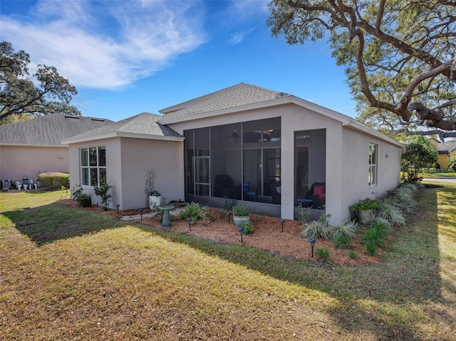 back of property with a lawn and a sunroom