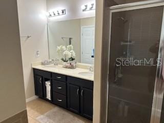 bathroom featuring tile patterned flooring, walk in shower, and vanity