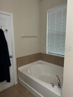 bathroom with a tub and tile patterned flooring