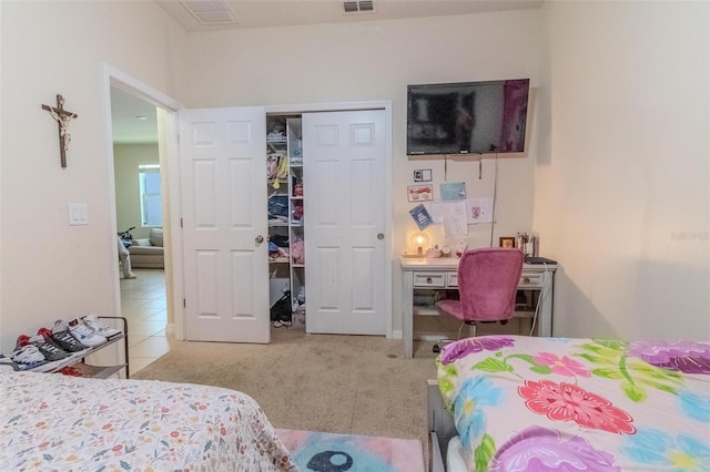 tiled bedroom featuring a closet, carpet flooring, and visible vents