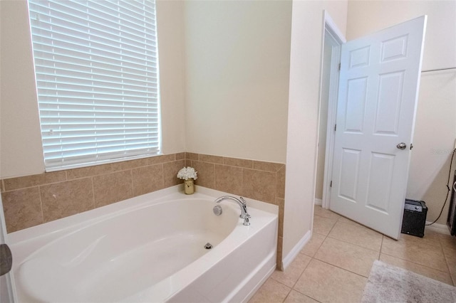 full bathroom featuring tile patterned flooring, a bath, and baseboards