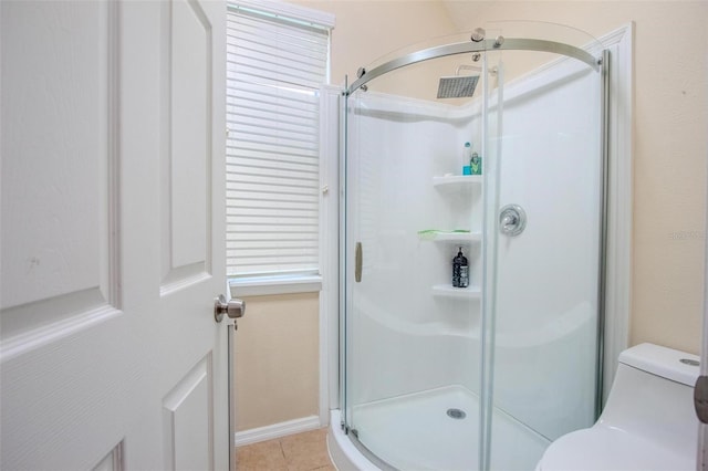 bathroom featuring a shower stall, toilet, and tile patterned floors