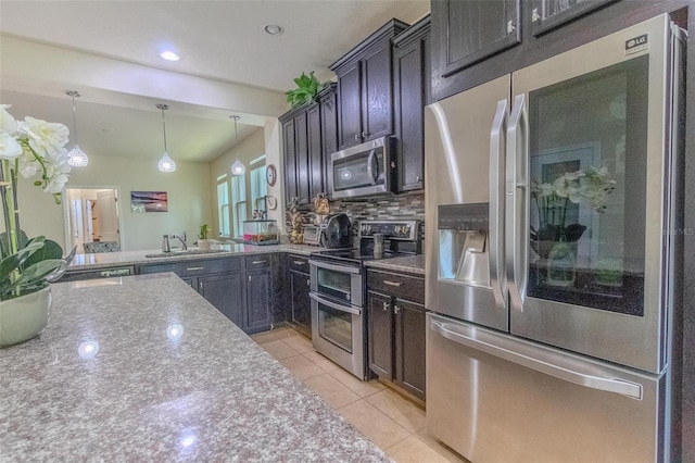 kitchen featuring light tile patterned floors, a sink, appliances with stainless steel finishes, decorative backsplash, and pendant lighting