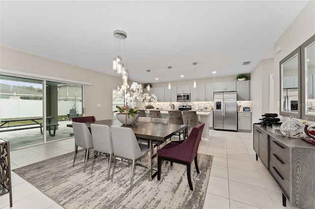 tiled dining room with a notable chandelier