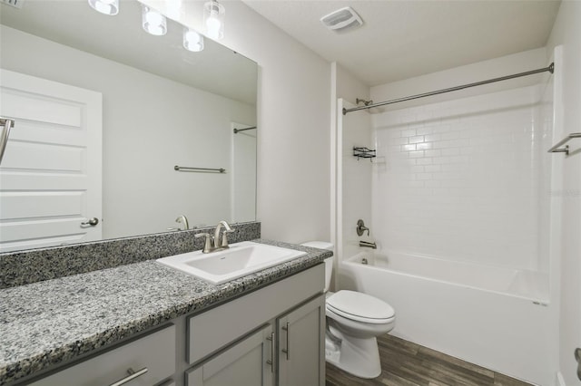 full bathroom featuring vanity, hardwood / wood-style flooring, shower / tub combination, and toilet