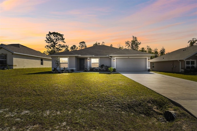 single story home featuring a garage and a lawn