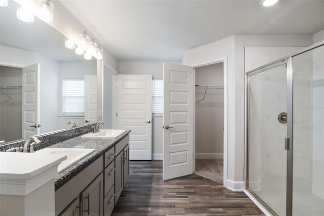 bathroom featuring hardwood / wood-style flooring, vanity, and a shower with shower door