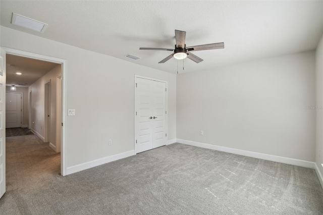 unfurnished bedroom featuring carpet floors, a closet, and ceiling fan