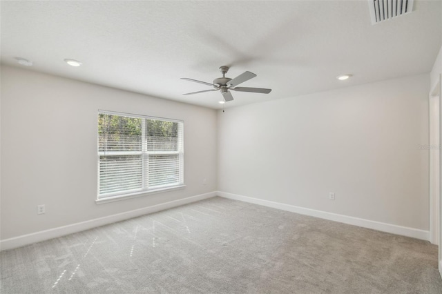 empty room featuring ceiling fan and light carpet