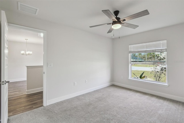 unfurnished room with carpet and ceiling fan with notable chandelier