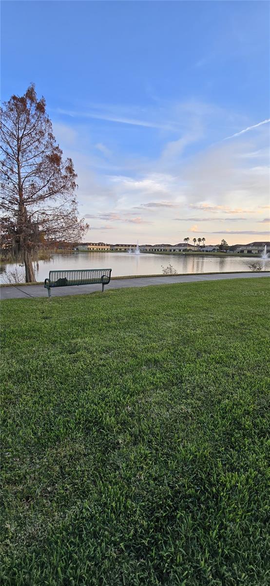 yard at dusk featuring a water view