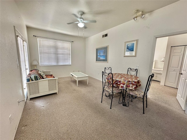 carpeted dining space featuring a textured ceiling and ceiling fan