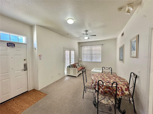 carpeted dining space featuring ceiling fan and a textured ceiling