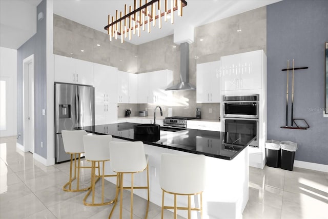 kitchen with white cabinets, wall chimney range hood, and stainless steel appliances