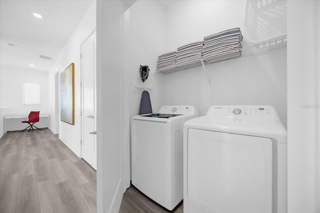 washroom with light hardwood / wood-style floors and independent washer and dryer