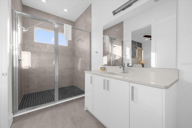 bathroom with walk in shower, vanity, and tile patterned flooring