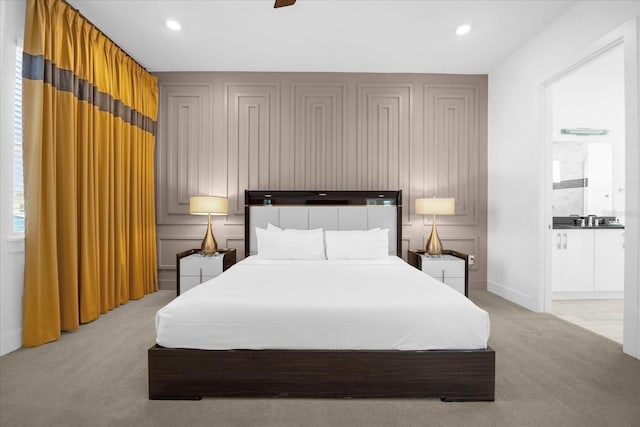 carpeted bedroom featuring ensuite bath and ceiling fan