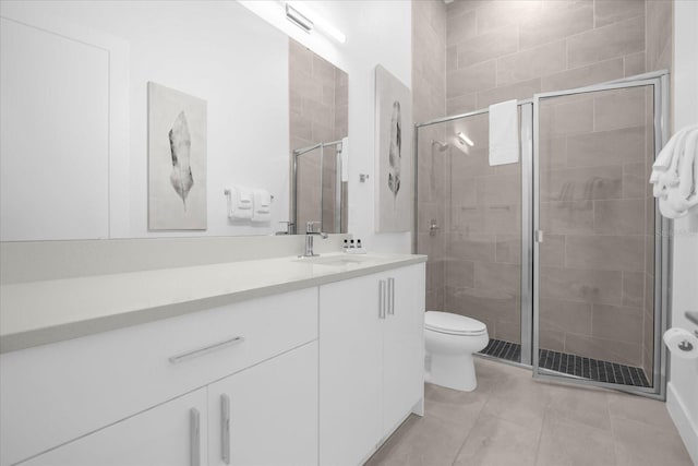 bathroom with vanity, a shower with shower door, and toilet