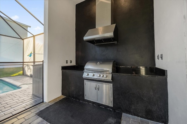 view of patio with a lanai, exterior kitchen, and a grill