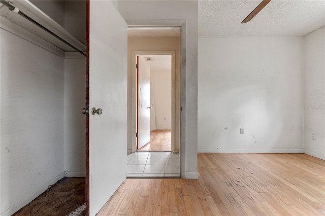 interior space featuring light hardwood / wood-style floors, a textured ceiling, and ceiling fan