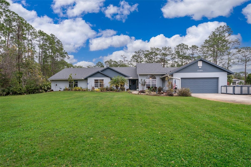 ranch-style house featuring a garage and a front lawn