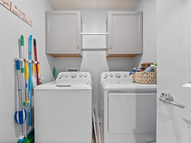 washroom with separate washer and dryer and cabinets