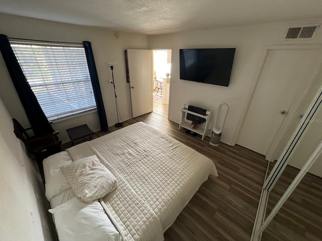 bedroom with dark wood-type flooring and a textured ceiling