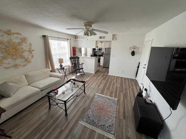 living room with wood-type flooring, a textured ceiling, and ceiling fan