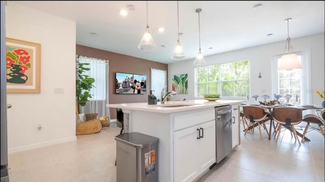 kitchen with white cabinetry, an island with sink, decorative light fixtures, stainless steel dishwasher, and sink