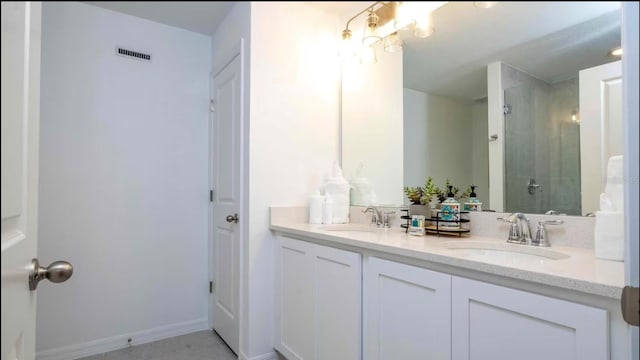 bathroom featuring vanity and tiled shower