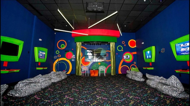 playroom featuring carpet and a drop ceiling