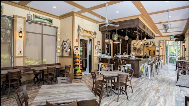 dining room featuring bar, ceiling fan, coffered ceiling, and hardwood / wood-style flooring