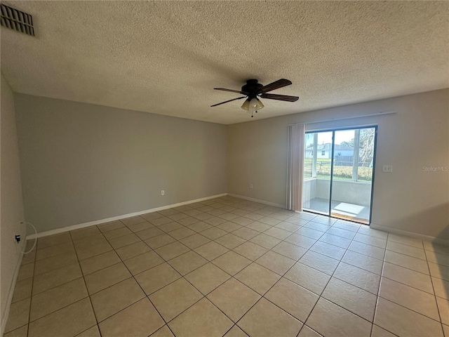 tiled empty room with ceiling fan and a textured ceiling